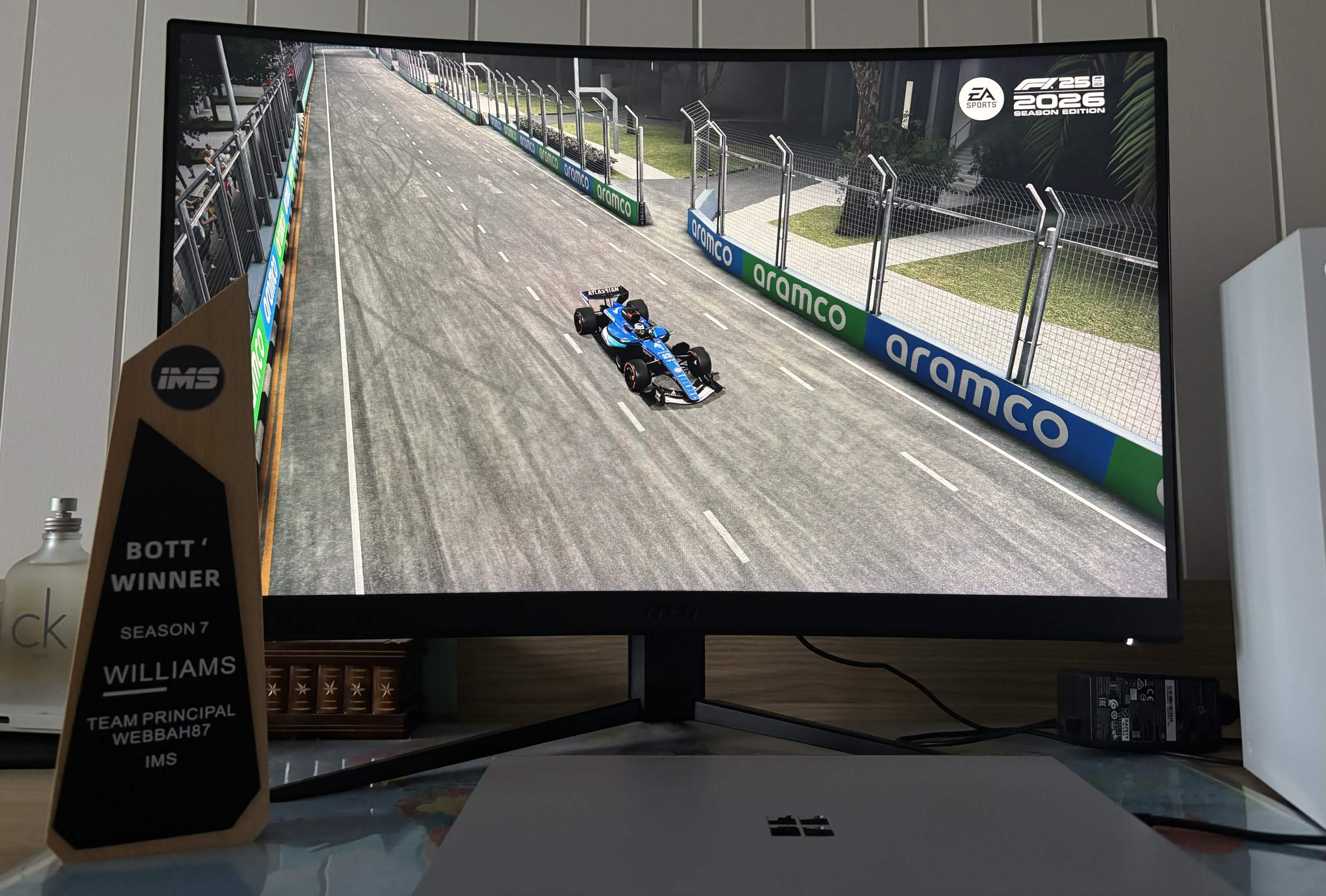 Webbah's Season 7 Williams BOTT trophy on his desk, with a Williams car displayed on his monitor.