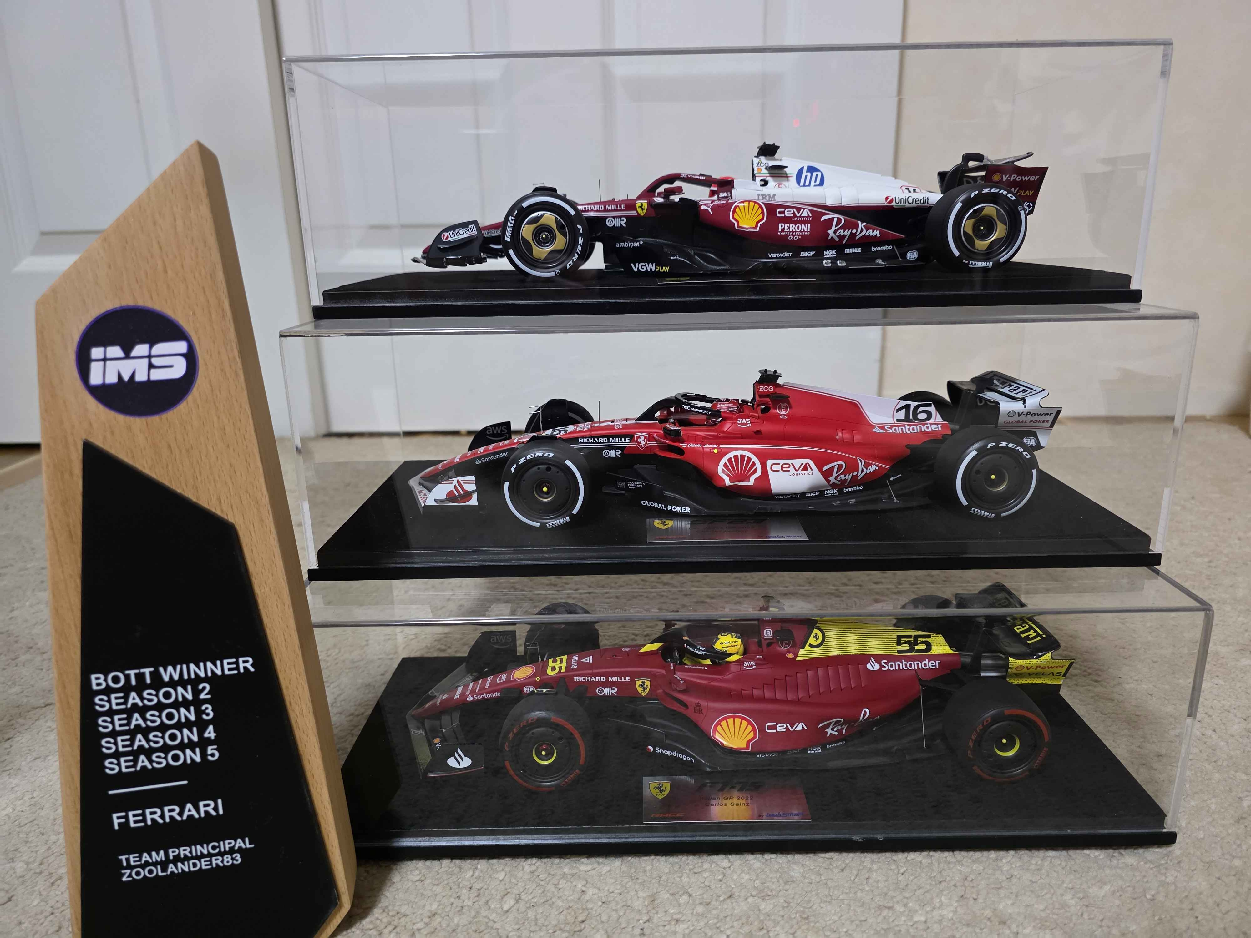 Zoolander's BOTT trophy for Ferrari's Seasons 2–5 titles beside three Ferrari model cars.